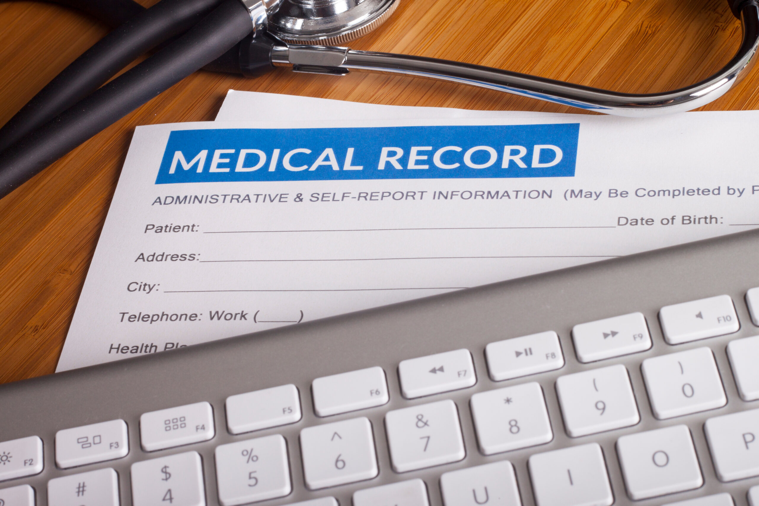 Stock image of a Medical records sheet and a computer keyboard.
